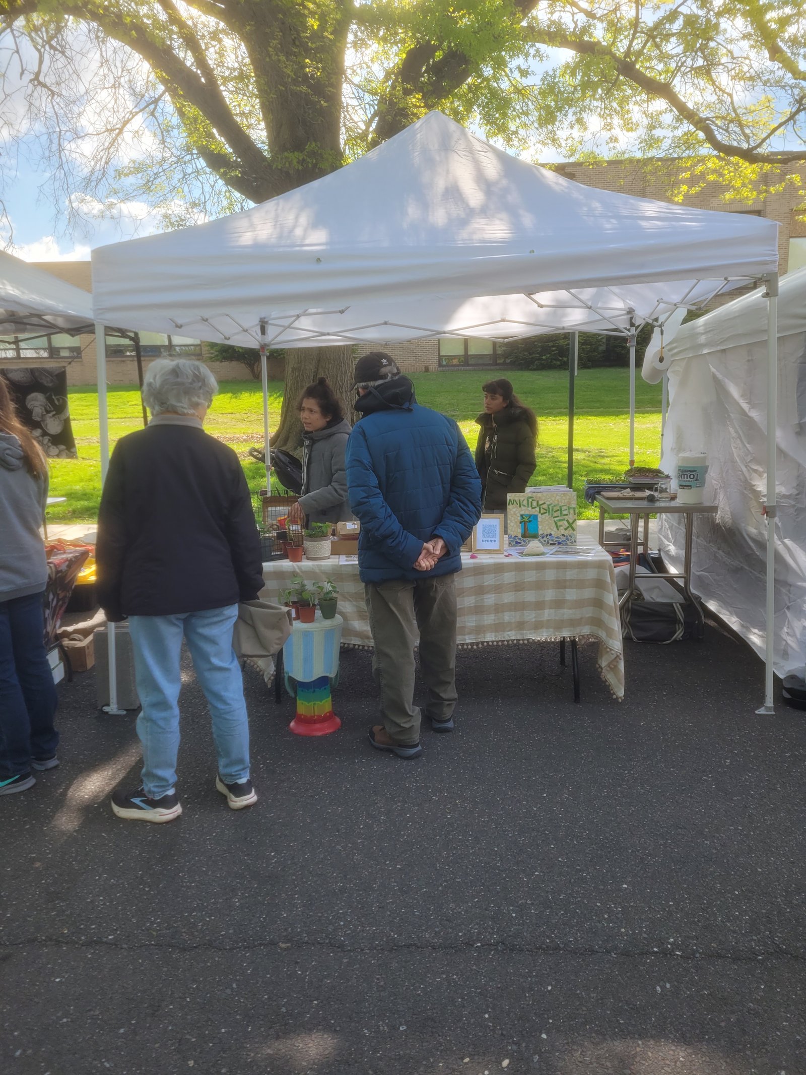 Xavier presenting microgreens trays with Fiona supervising at the microGREEN FX booth, North Wales Farmers Market opening day, 2026
